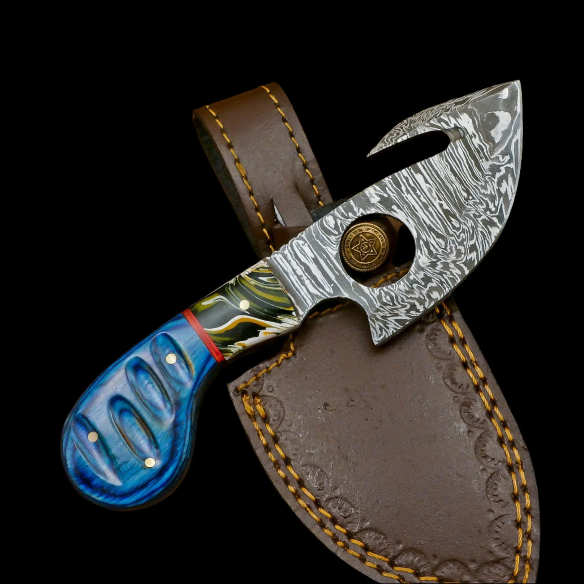 Decorative knife with a blue handle and silver blade in a brown leather sheath on a wooden surface