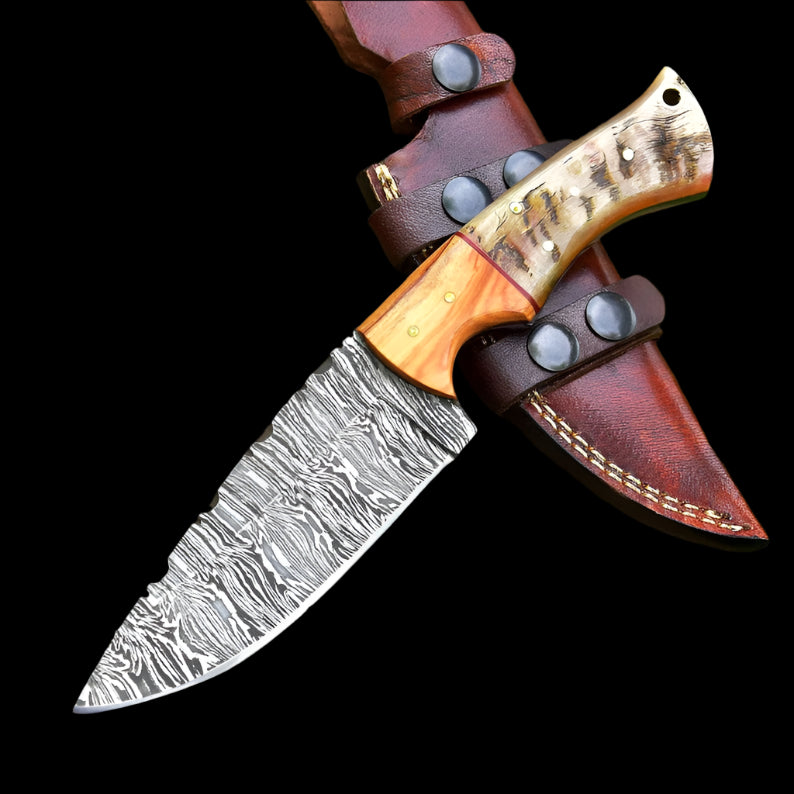 Knife with wooden handle and leather sheath on a tree trunk