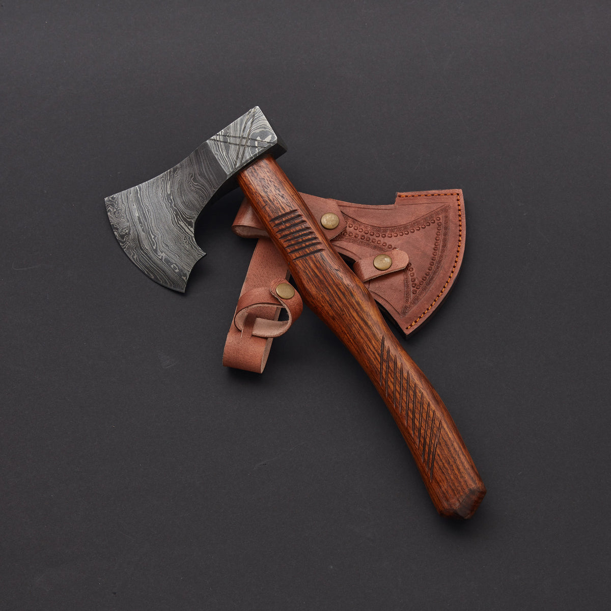 A handmade axe with a Damascus steel blade and a rosewood handle with a leather sheath.