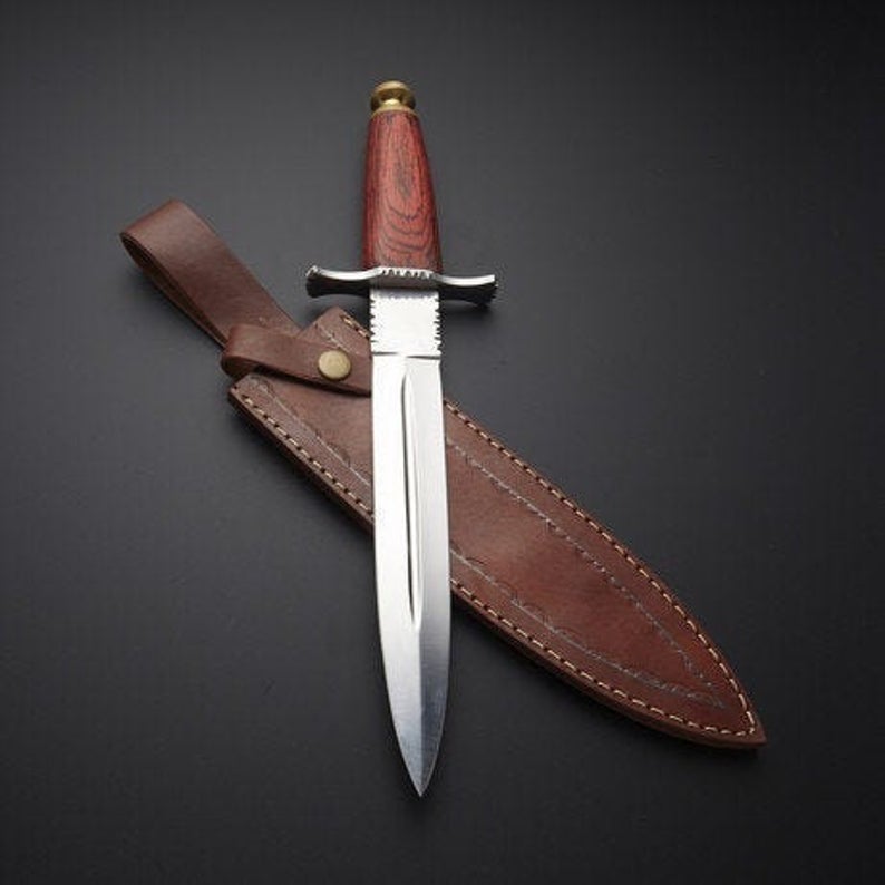 A handmade hunting knife with a wooden handle and a leather sheath, displaying the blade and the handle's detailed stitching.