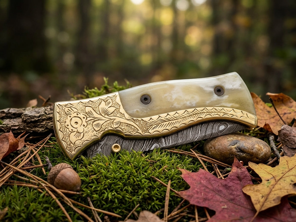 Damascus steel folding knife with engraved bolster and cow bone handle