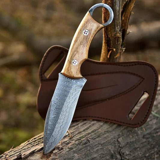 Knife with wooden handle and leather sheath on a wooden surface