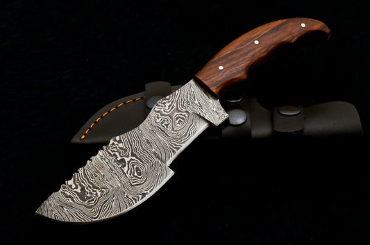 Handmade Damascus steel tracker knife with a patterned blade and rosewood handle, accompanied by a black leather sheath.